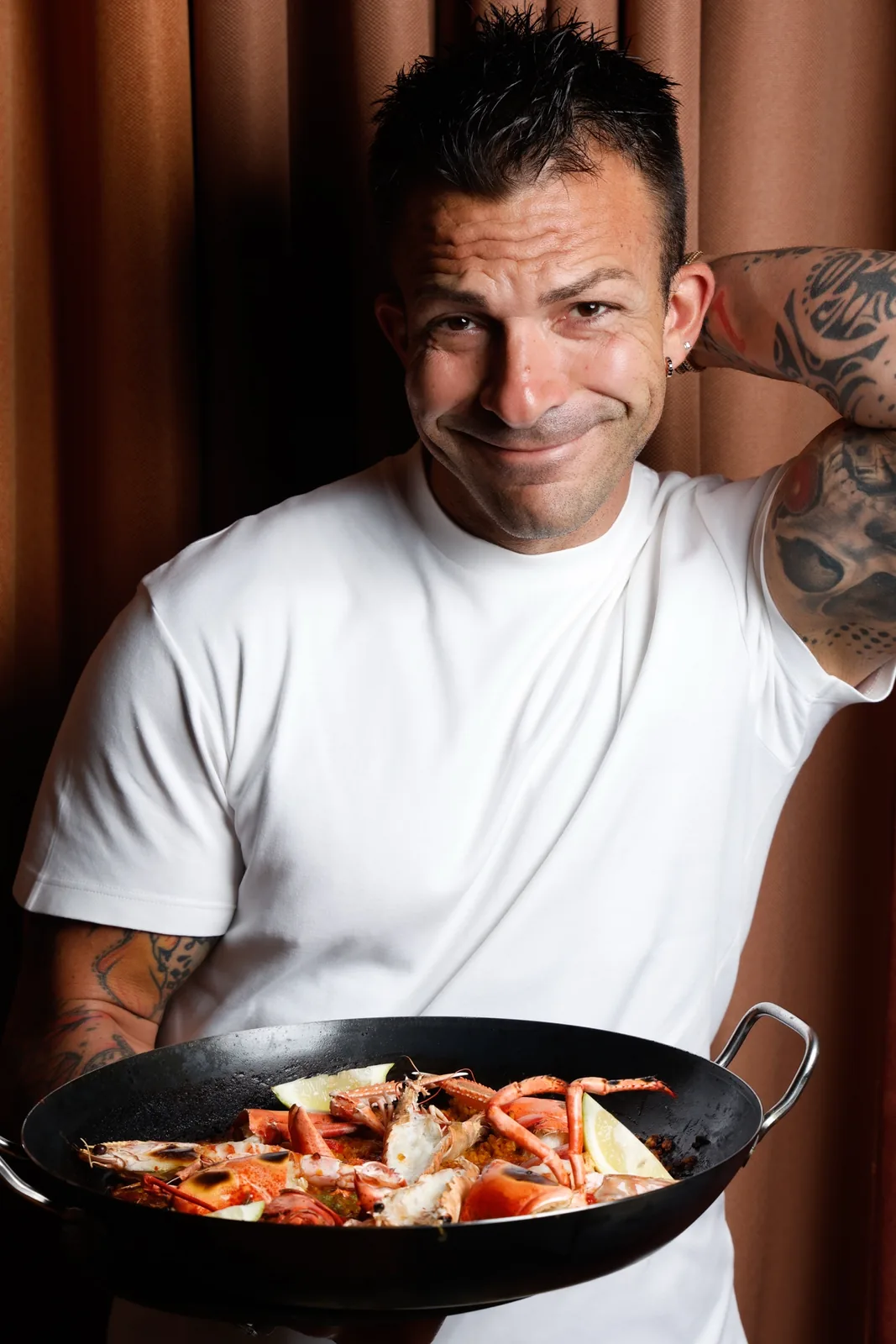 Cuoco con paella ai frutti di mare